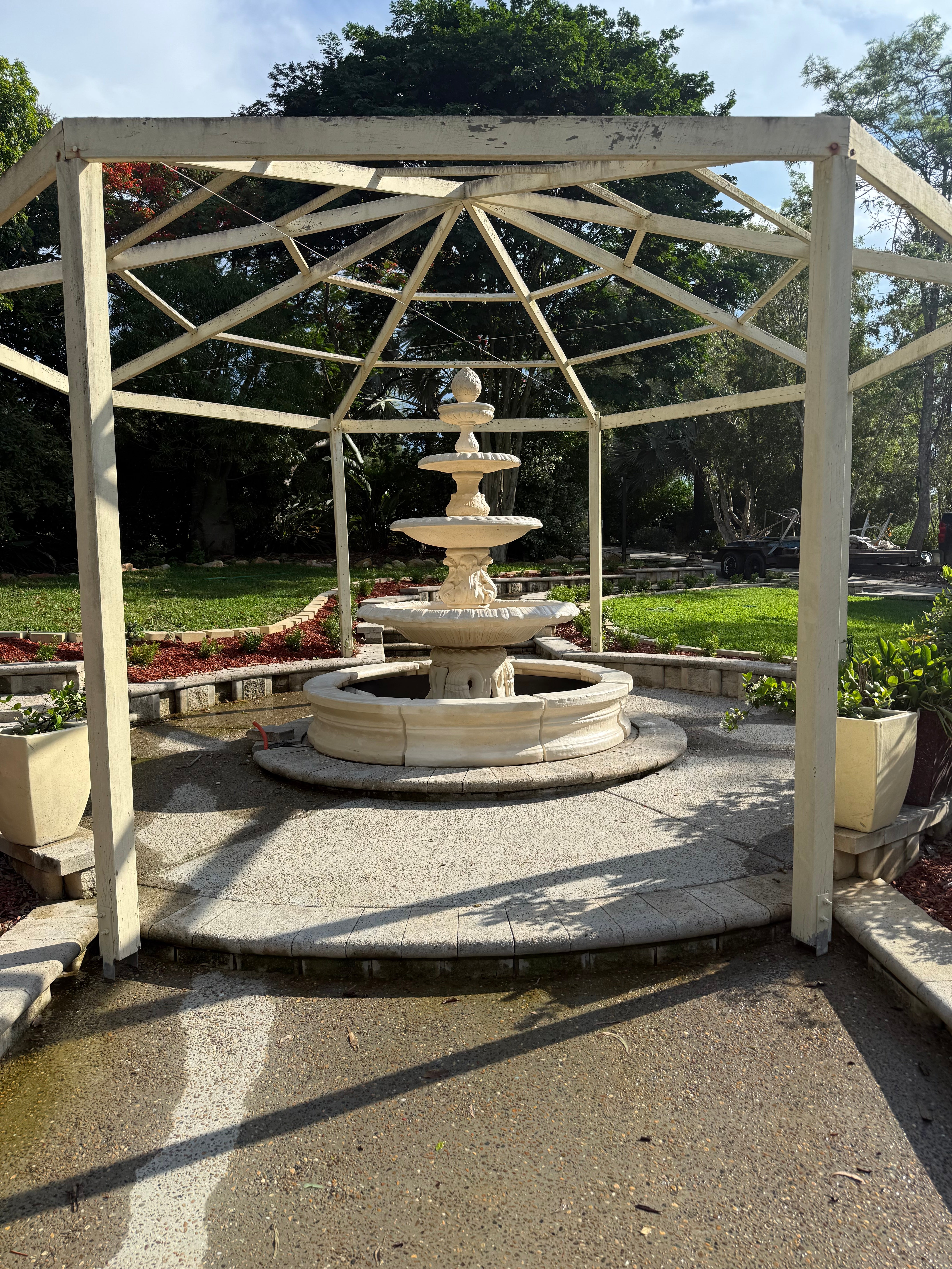 4 tier Italian fountain with round acorn in traditional pond surround